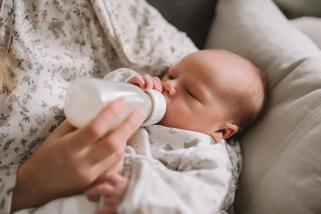 Partner geeft fles aan baby